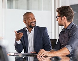 a man with dentures talking with a colleague