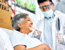Dentist showing smiling patient reflection