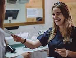 Happy dental team member holding paperwork