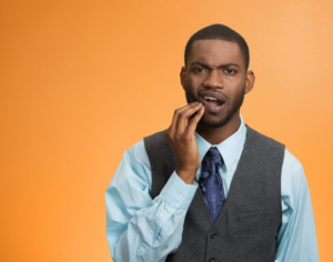 Man rubbing his jaw and looking concerned about gingivitis 